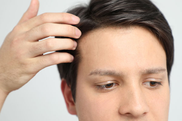 man touching full head of hair