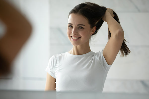 woman touching full head of hair woman touching full head of hair