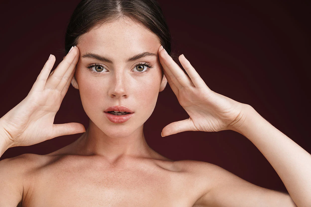 Close-up of a woman's face, hands framing her head. Close-up of a woman's face, hands framing her head.