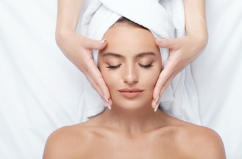 Woman receiving a facial massage.
